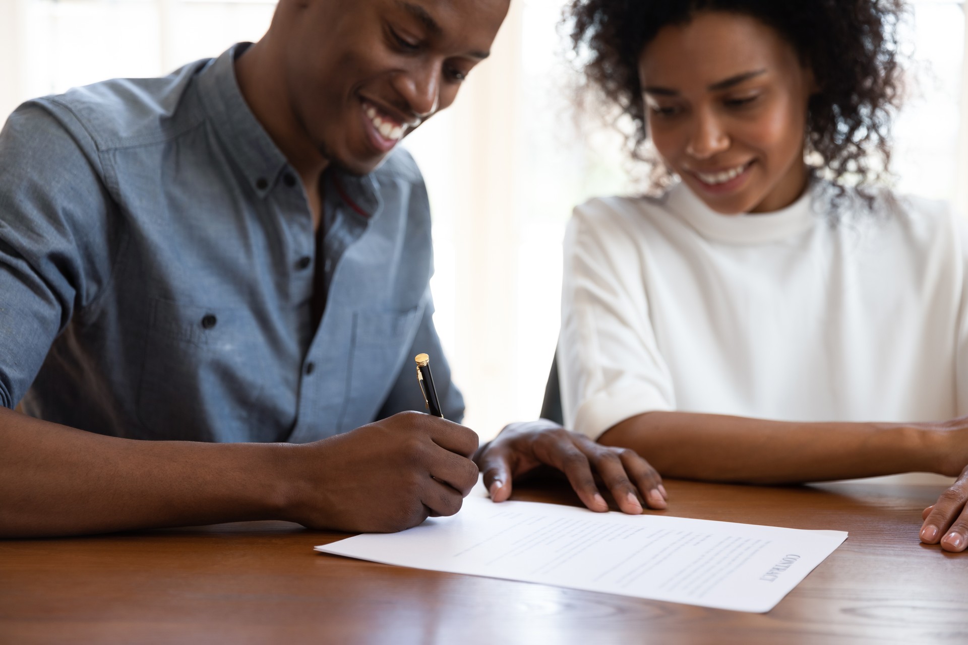 Focus on male hands, holding pen, signing contract.